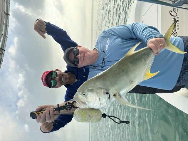 Two anglers holding a jack crevalle off Key West