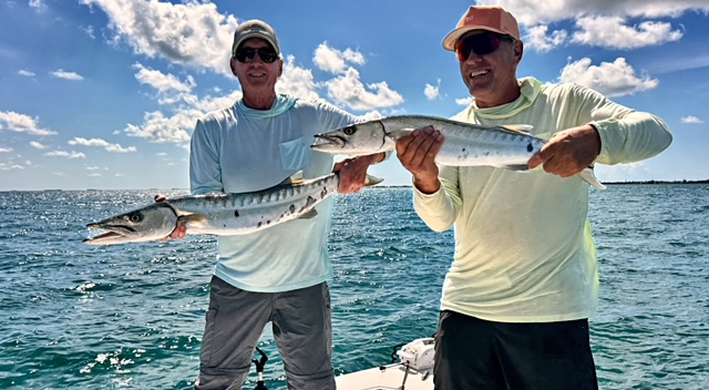 Two anglers each holding a barracuda off Key West