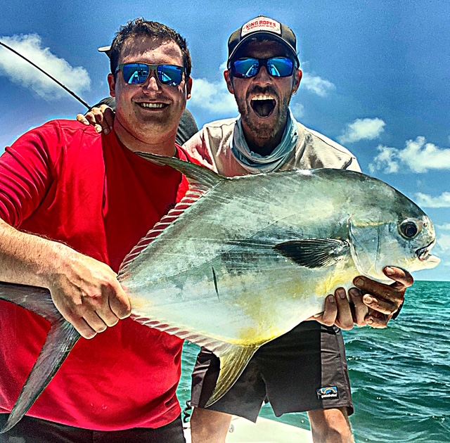Two anglers holding a permit caught on the Key West flats
