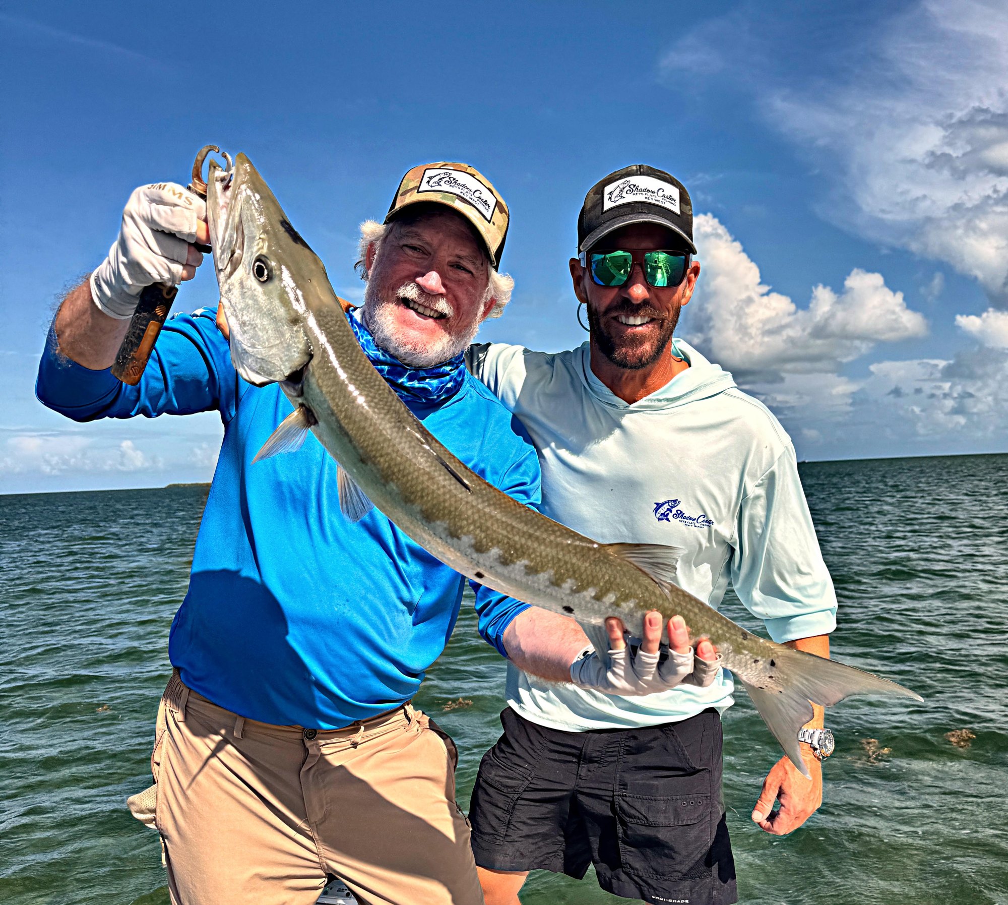 Anglers holding a barracuda caught on a seven hour Key West fishing charter