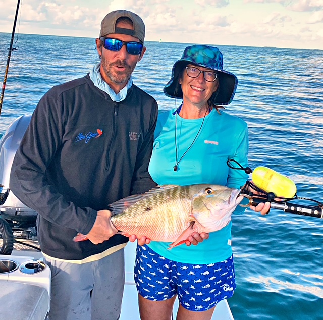 Couple holding a mutton snapper on a Key West charter