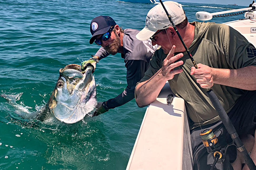 Captain and angler leadering a tarpon boatside on a Key West fishing charter