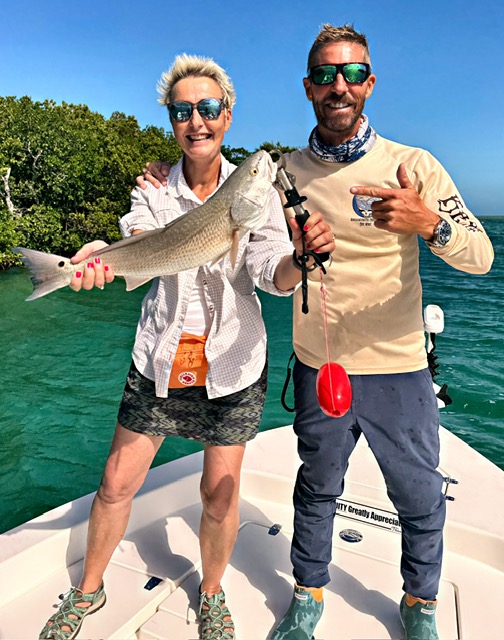 Guest holding a redfish on a Key West backcountry charter