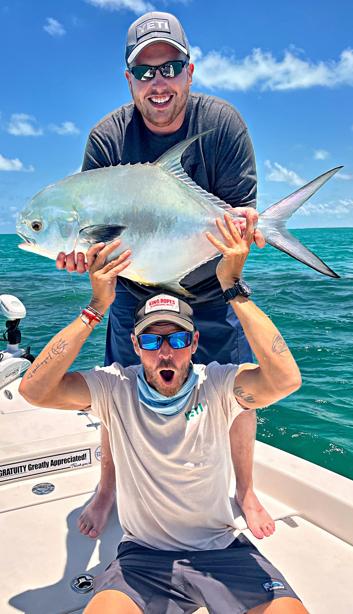 Angler hoisting a permit on a friend's shoulders on a Key West charter