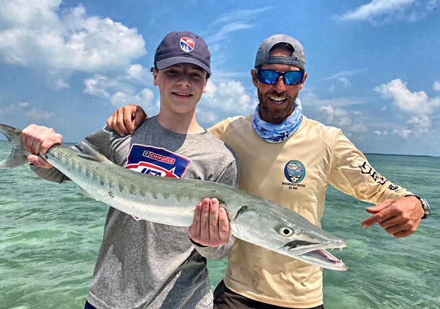 Teenager and captain with a barracuda in shallow Key West water
