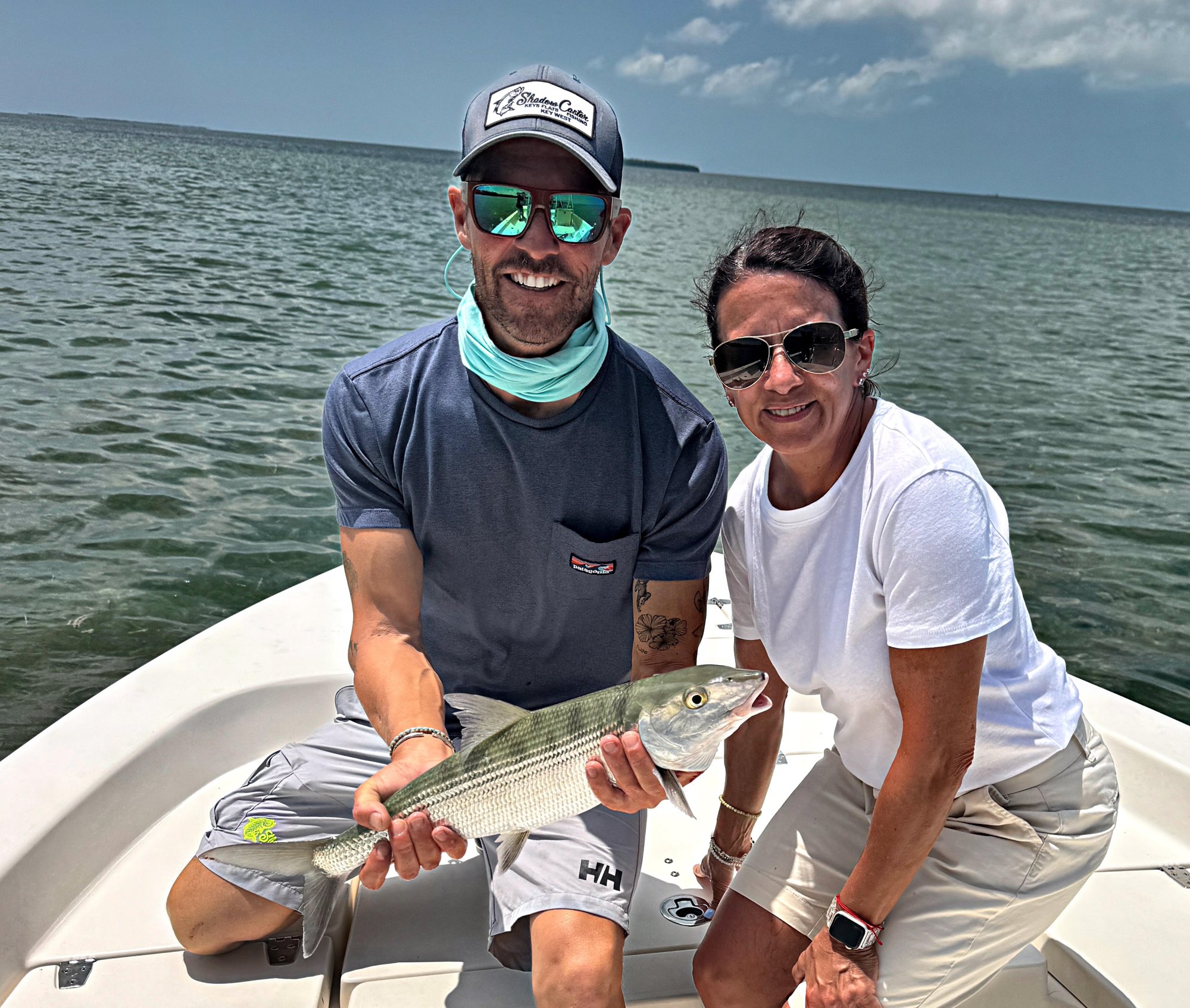 Couple on the bow holding a bonefish caught on a half day Key West fishing charter