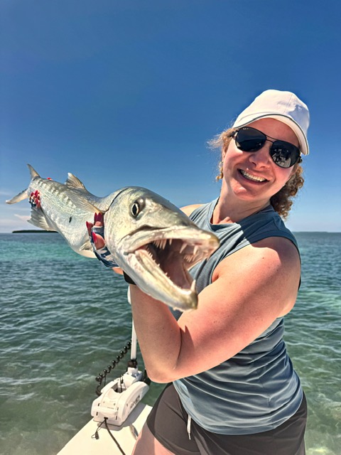 Guest holding a barracuda up close on a Key West charter