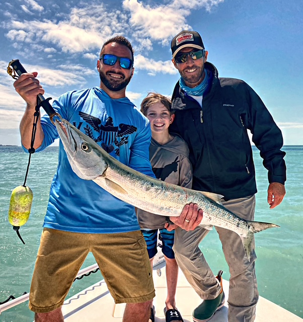 Family posing with a barracuda on a Key West charter
