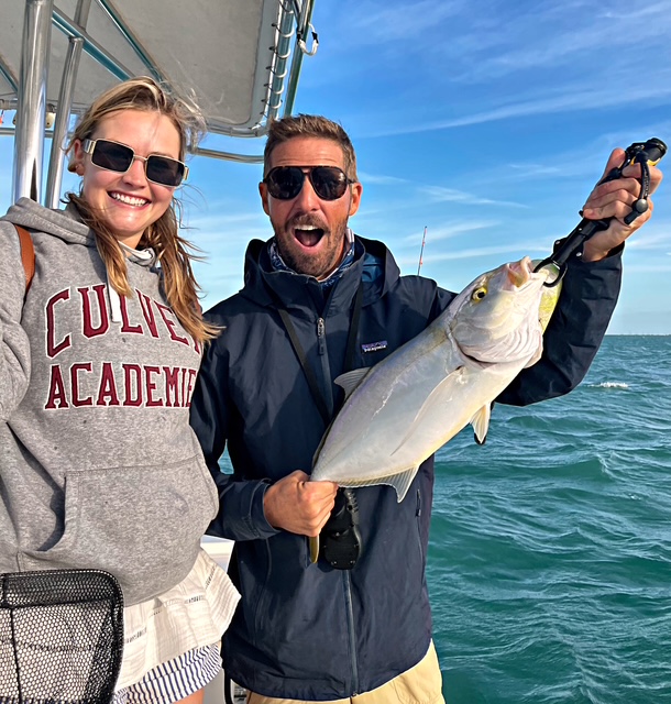 Guests laughing with an amberjack on a Key West charter