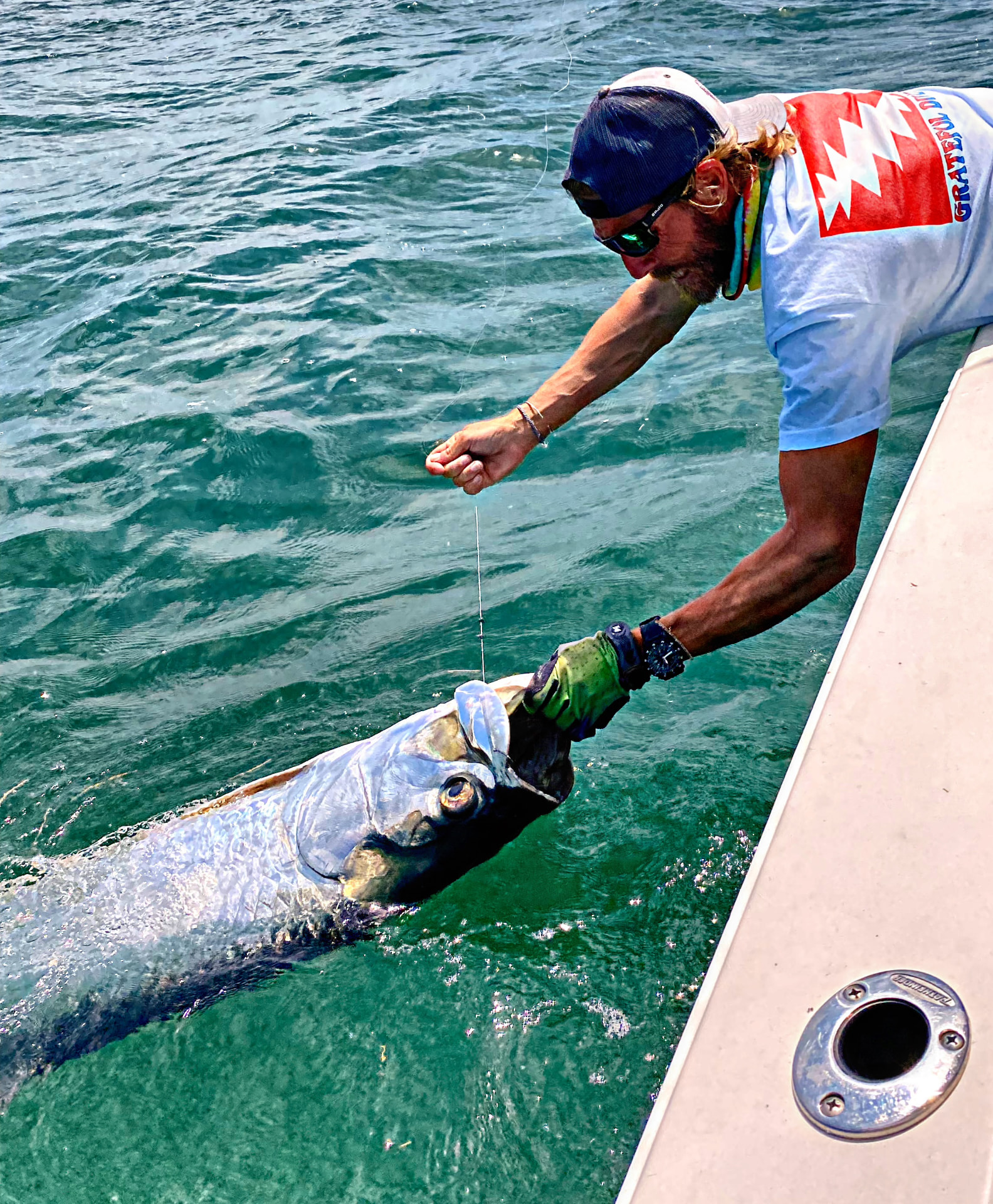 Capt. Justin “Juice” Valakis releasing a tarpon boatside in Key West